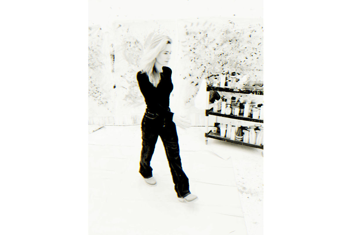 Nashville abstract painter Angela Simeone walking through her studio past leaning canvases, the direct studio route a collector takes when there is no advisor or gallery in between