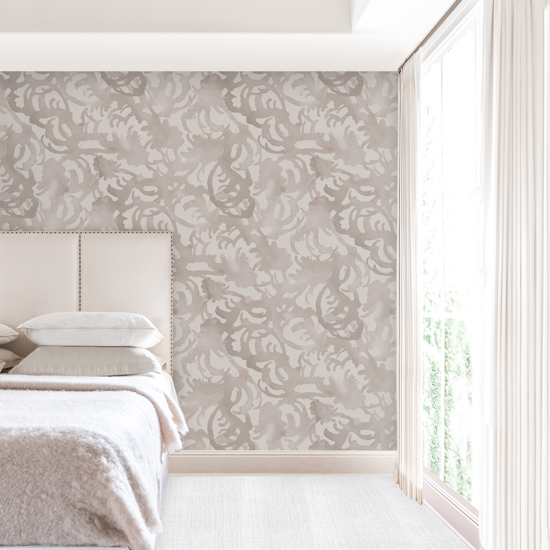 Flourish Greige artist-designed wallpaper on a primary bedroom wall behind a linen headboard, drawn from an original painting by Nashville artist Angela Simeone, from a post on who actually authors a wallpaper house's patterns.