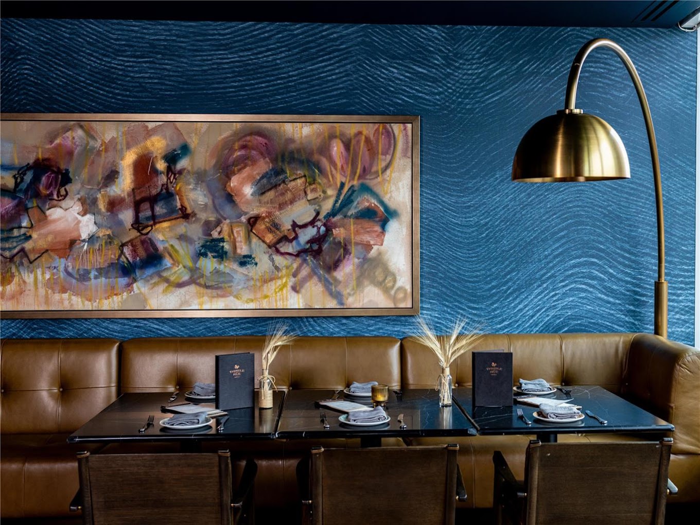 Original abstract painting by Angela Simeone installed above the leather banquette at Thistle & Rye, the Conrad Nashville's restaurant, interiors by Champalimaud Design